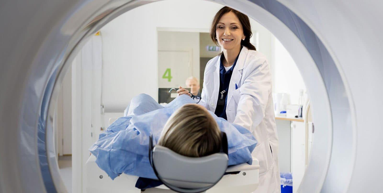 A neurologist guiding a patient into an MRI scanner