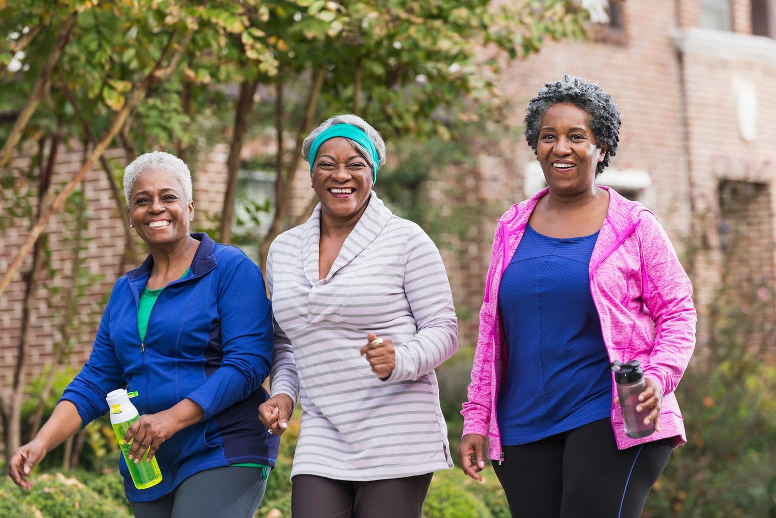 Three women walking together outdoors in athletic wear
