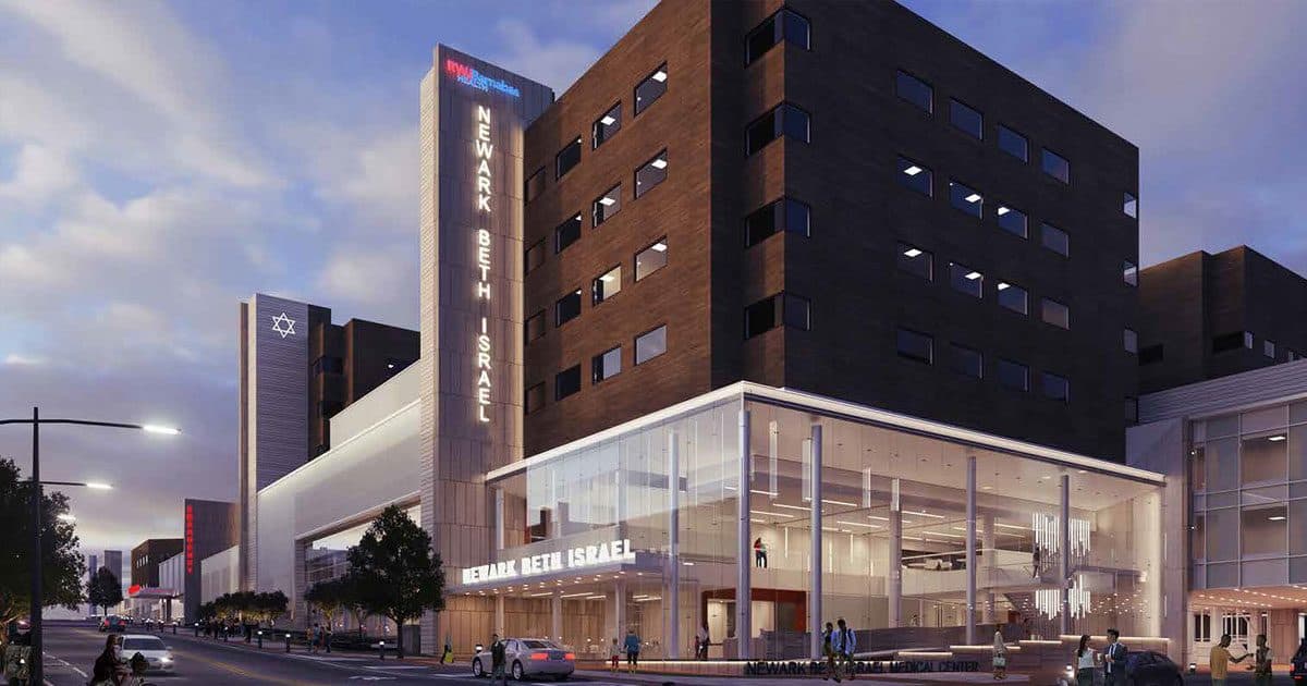 Newark Beth Israel Medical Center's glass entrance and tower at dusk