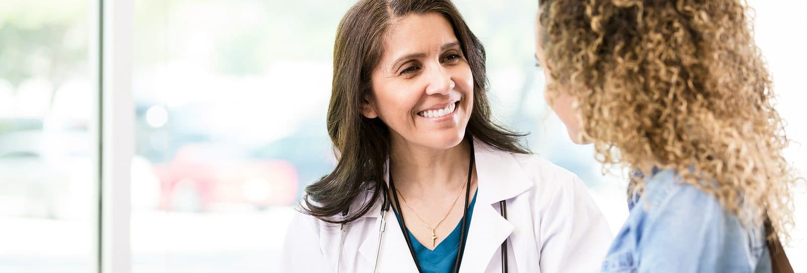 A smiling doctor talking with a patient in a bright clinic